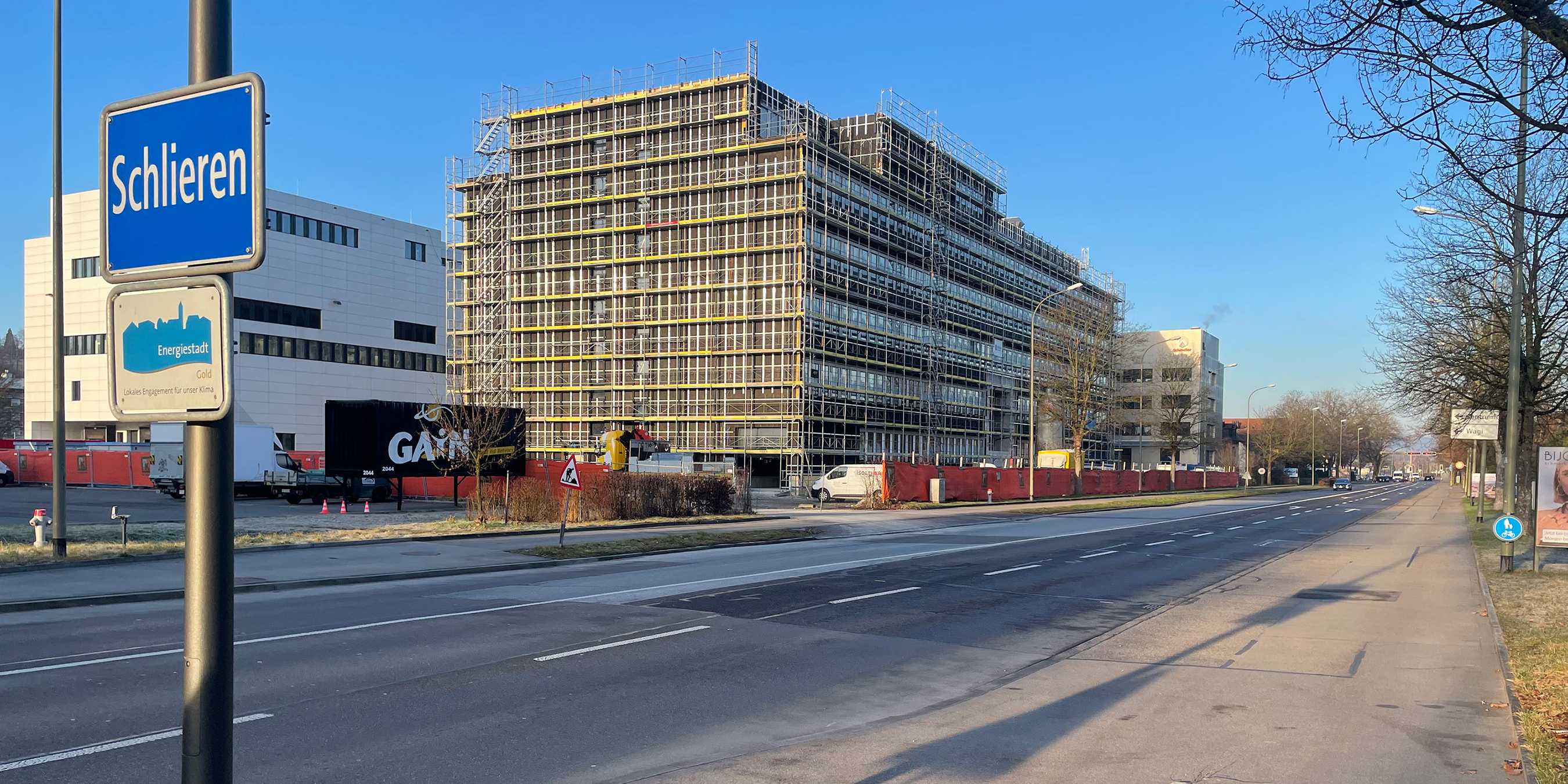 Ortstafel "Schlieren" im Hintergrund das Gebäude im Baugerüst.