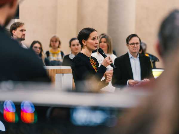Anastasiya Ponomaryova spricht mit einem Mikrofon in der Hand.