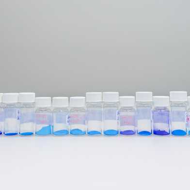 Tins stand next to each other and contain powder in different shades of blue.