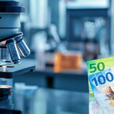 A microscope in the left half of the picture, in the right half a hand holding banknotes to the left.