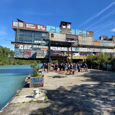 A spray-painted building next to a river